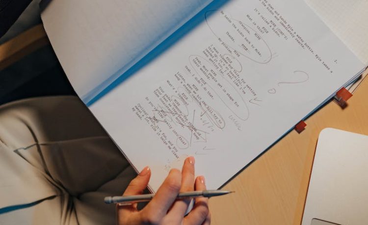 Person Holding Pen Writing on White Paper