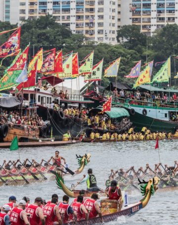 group of people riding dragon boat on water