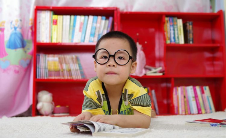 Boy Standing Near Bookshelf