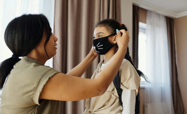 Mother Putting a Face Mask on her Daughter