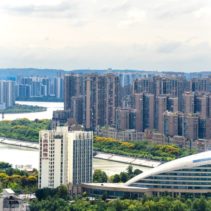 Aerial view of a modern cityscape with tall buildings and a winding river.